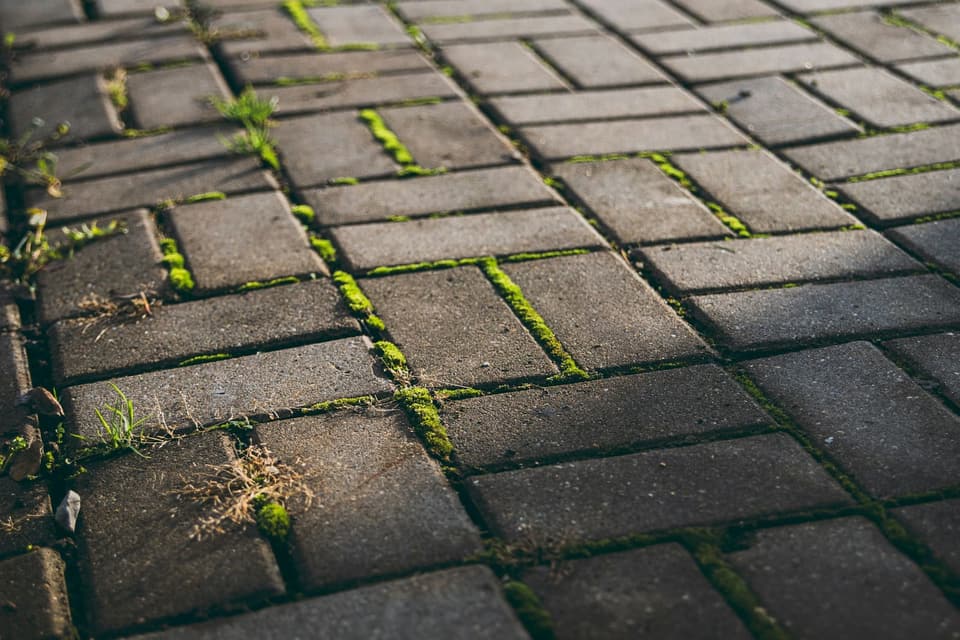 A pressure washer cleaning paving stones