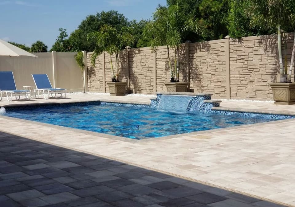 A swimming pool bordered by a paver deck